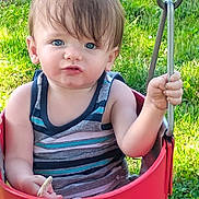 Odon is registered to the contest to win money with this photo: toddler, child, swing, outdoor, grass, blue_eyes, tank_top, striped_clothing, summer, playground, baby, holding, pacifier, hand, face, expression, sunlight, nature, fun, play