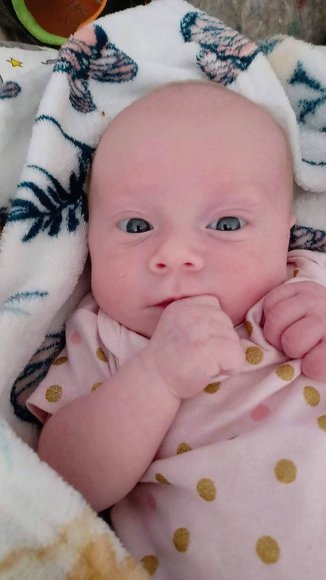 Lilith is registered to the contest to win money with this photo: baby, baby_toddler_clothing, cheek, comfort, face, finger, gesture, hand, iris, linens, lip, nail, nose, person, pink, product, skin, textile, thumb, toddler