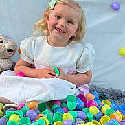 Madison joined the competition — help win amazing prizes! child, girl, smile, easter_eggs, colorful, plastic_eggs, plush_toy, bunny, white_dress, hair_bow, happy, indoor, soft_rug, toy, cute, festive, celebration, baby, portrait, playful
