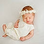 newborn, baby, sleeping, white_outfit, floral_headband, soft, peaceful, infant, cute, portrait, child, resting, skin, hand, foot, closed_eyes, adorable, cozy, lying_down, minimalist_background