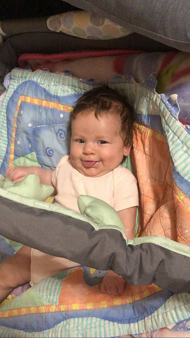 Jenna is registered to the contest to win money with this photo: baby, baby_products, baby_toddler_clothing, cheek, child, comfort, eye, fun, happy, head, iris, joy, lap, linens, mammal, person, product, sitting, skin, smile