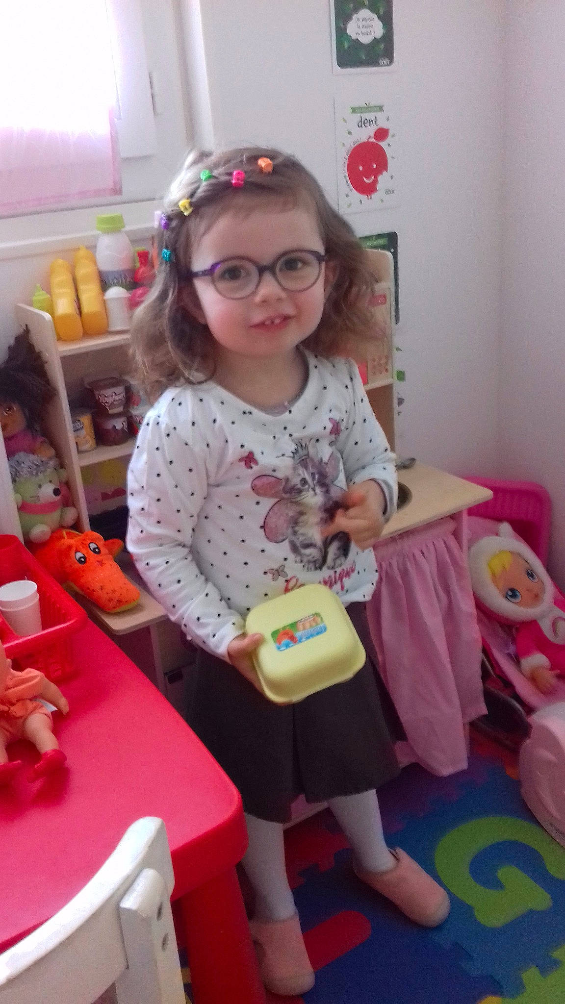 Cécilia a rejoint le concours — aidez-le/la à gagner de superbes lots ! baby_toddler_clothing, child, event, eyewear, fun, glasses, happy, magenta, pattern, person, pink, purple, room, sitting, sleeve, smile, sock, t_shirt, toddler, toy