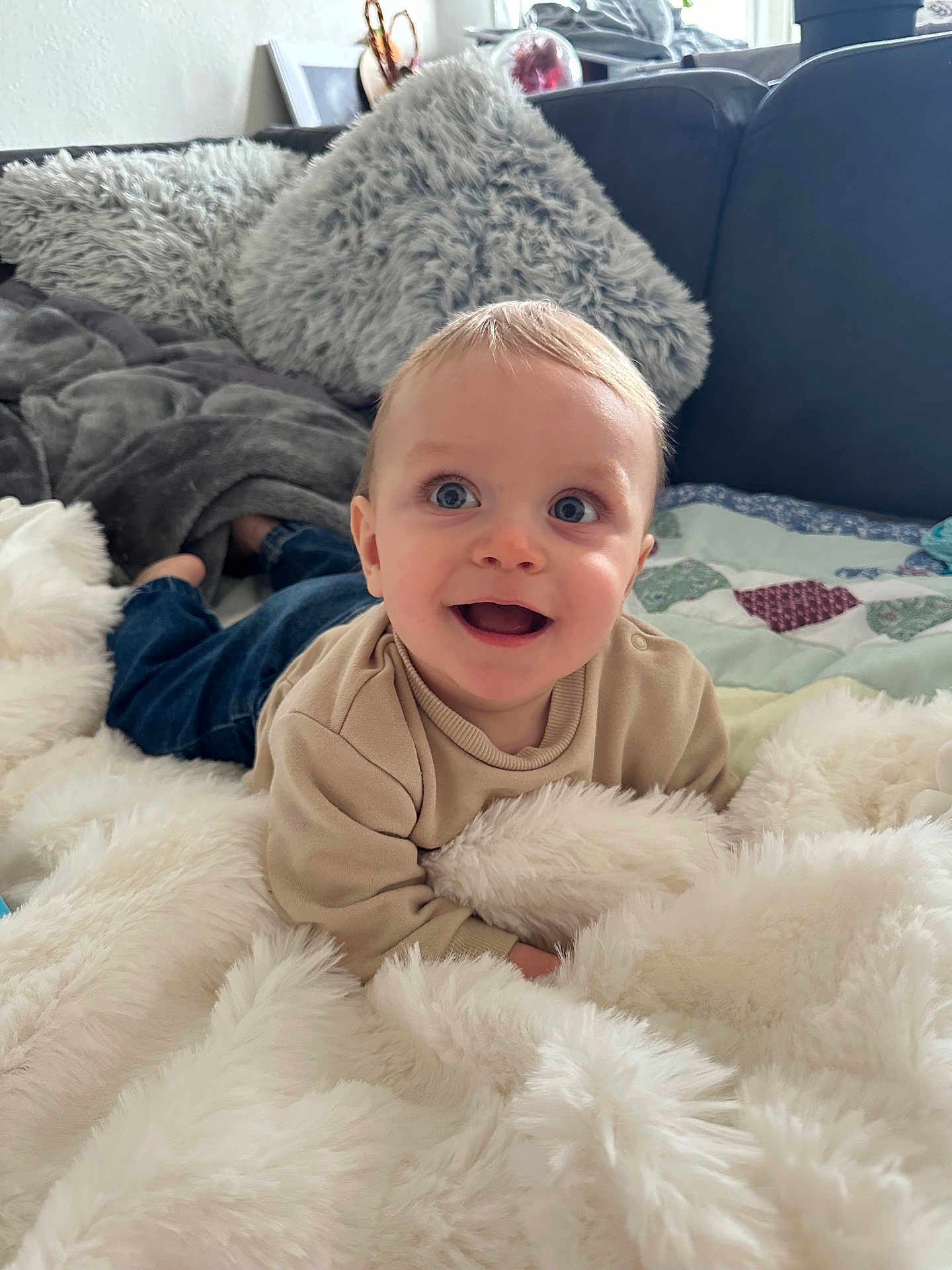 Gabriel a rejoint le concours — aidez-le/la à gagner de superbes lots ! baby, child, smiling, blue_eyes, blanket, couch, pillow, indoor, happy, cozy, soft_texture, casual_clothing, infant, portrait, home, cute, young_child, relaxing, comfort, playful