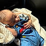 baby, sleeping, blanket, denim_overalls, car_interior, sunlight, infant, cozy, child, cute, hand, clothing, seat, soft_texture, portrait, peaceful, resting, daylight, small_child, casual_wear