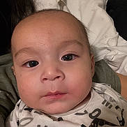 Noah joined the competition — help win amazing prizes! baby, face, infant, portrait, onesie, clothing, person, child, young, head, eyes, skin, expression, indoor, pillow, resting, human, closeup, cute, youngchild