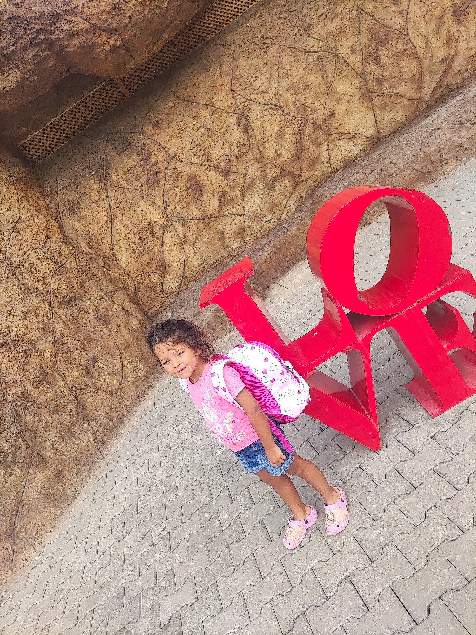 Kenza participe au concours pour gagner de l'argent avec cette photo : art, brick, eyewear, flooring, font, fun, happy, joy, landscape, leisure, magenta, pattern, person, road_surface, sidewalk, sitting, street, sunglasses, textile, tints_and_shades