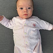Anna participe au concours pour gagner de l'argent avec cette photo : baby, infant, onesie, pink_clothing, face, eyes, buttoned_clothing, lying_down, texture, gray_background, portrait, cute, young_child, small_hands, soft_fabric, looking_at_camera, skin, head, expression, close_up