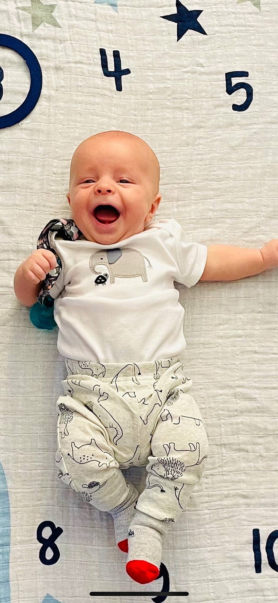 Konnan is registered to the contest to win money with this photo: baby, baby_laughing, baby_toddler_clothing, child, comfort, facial_expression, flooring, font, fun, gesture, happy, outerwear, pattern, person, play, sleeve, smile, standing, t_shirt, toddler