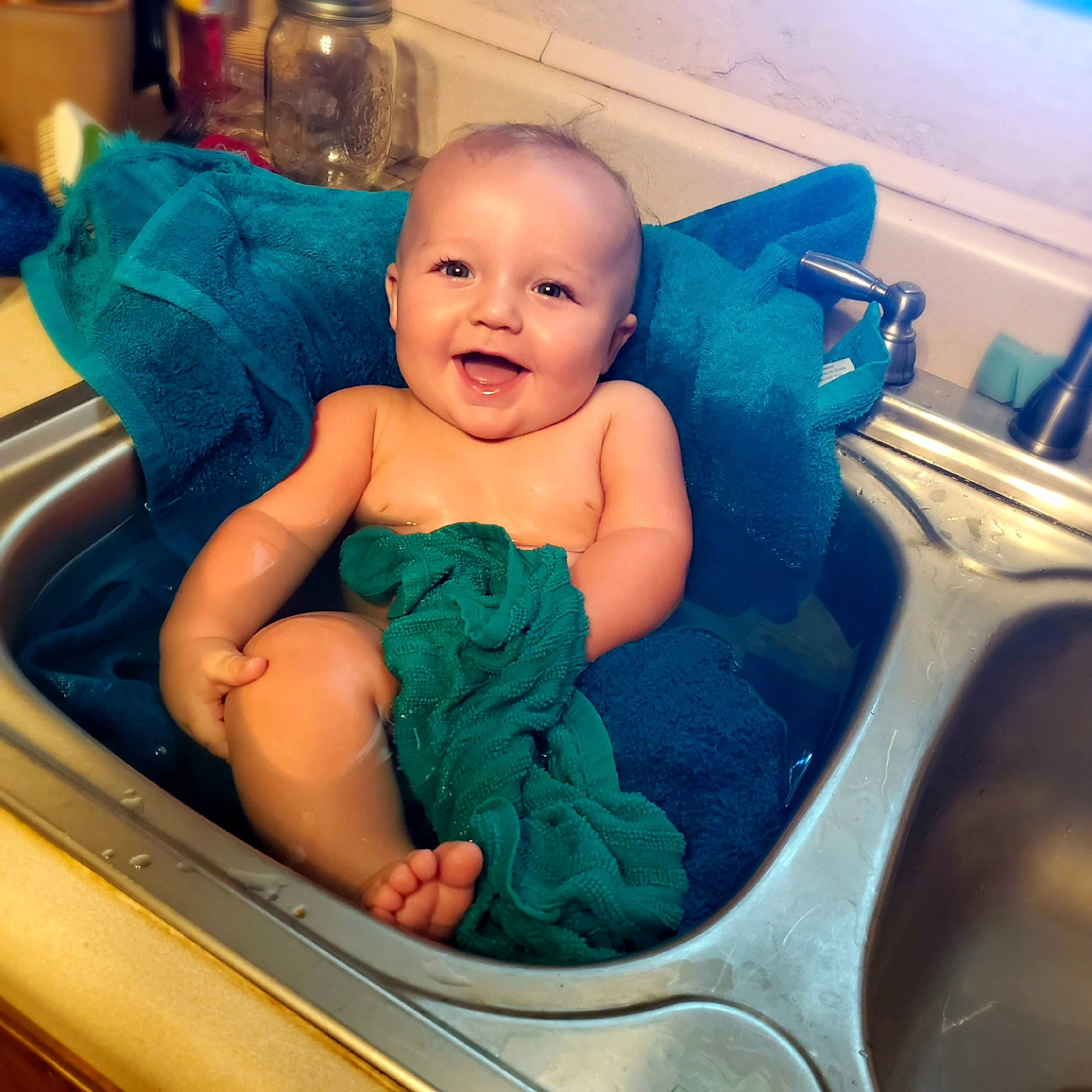 Turner is registered to the contest to win money with this photo: baby, baby_bathing, birth, cheek, child, eye, face, happy, head, joy, person, sitting, skin, smile, toddler, turquoise