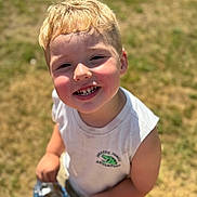 Grayson is registered to the contest to win money with this photo: blonde_hair, boy, casual_clothing, cheerful, child, chips, closeup, daylight, face, grass, happy, outdoor, person, portrait, smiling, snack, summer, sunlight, white_shirt, young