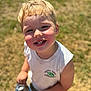 child, boy, smiling, blonde_hair, outdoor, sunlight, grass, snack, chips, casual_clothing, white_shirt, portrait, happy, young, face, person, summer, daylight, closeup, cheerful