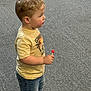 Grayson is registered to the contest to win money with this photo: bodypart, boy, candy, child, clothing, cream, dessert, face, finger, food, hand, head, jeans, male, pants, person, photography, portrait, sweets, t_shirt