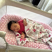Kehlani is registered to the contest to win money with this photo: baby, sleeping, blanket, bassinet, pink, heart_pattern, mesh, cozy, indoor, child, resting, infant, soft, comfort, cushion, clothing, peaceful, nursery, fabric, toddler
