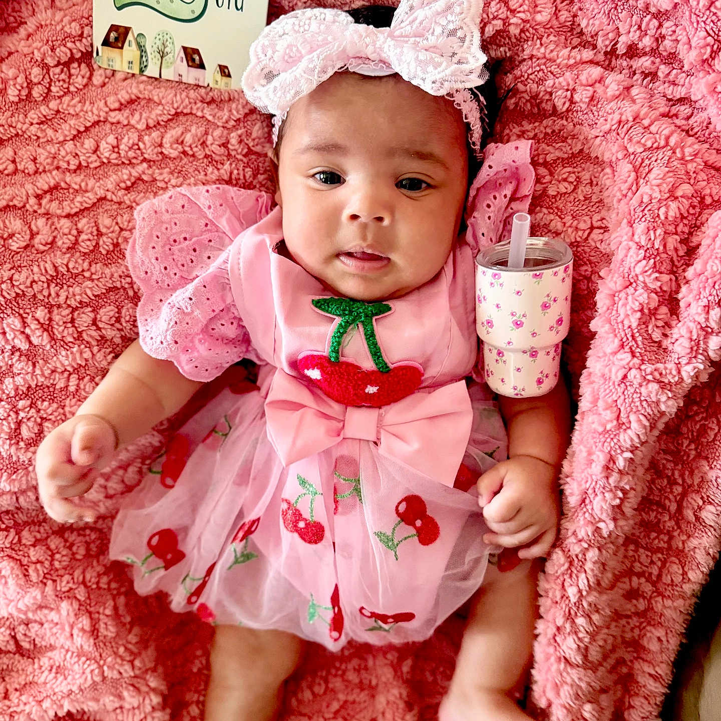 Kehlani joined the competition — help win amazing prizes! baby, infant, pink, dress, headband, bow, cherry, blanket, fluffy, sippy_cup, pattern, cute, child, portrait, smiling, happy, two_months, sign, clothing, laying