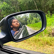 Kaison joined the competition — help win amazing prizes! child, car, side_mirror, reflection, pouting, outdoor, greenery, road, trees, nature, vehicle, window, portrait, face, playful, travel, boy, casual, daytime, expression