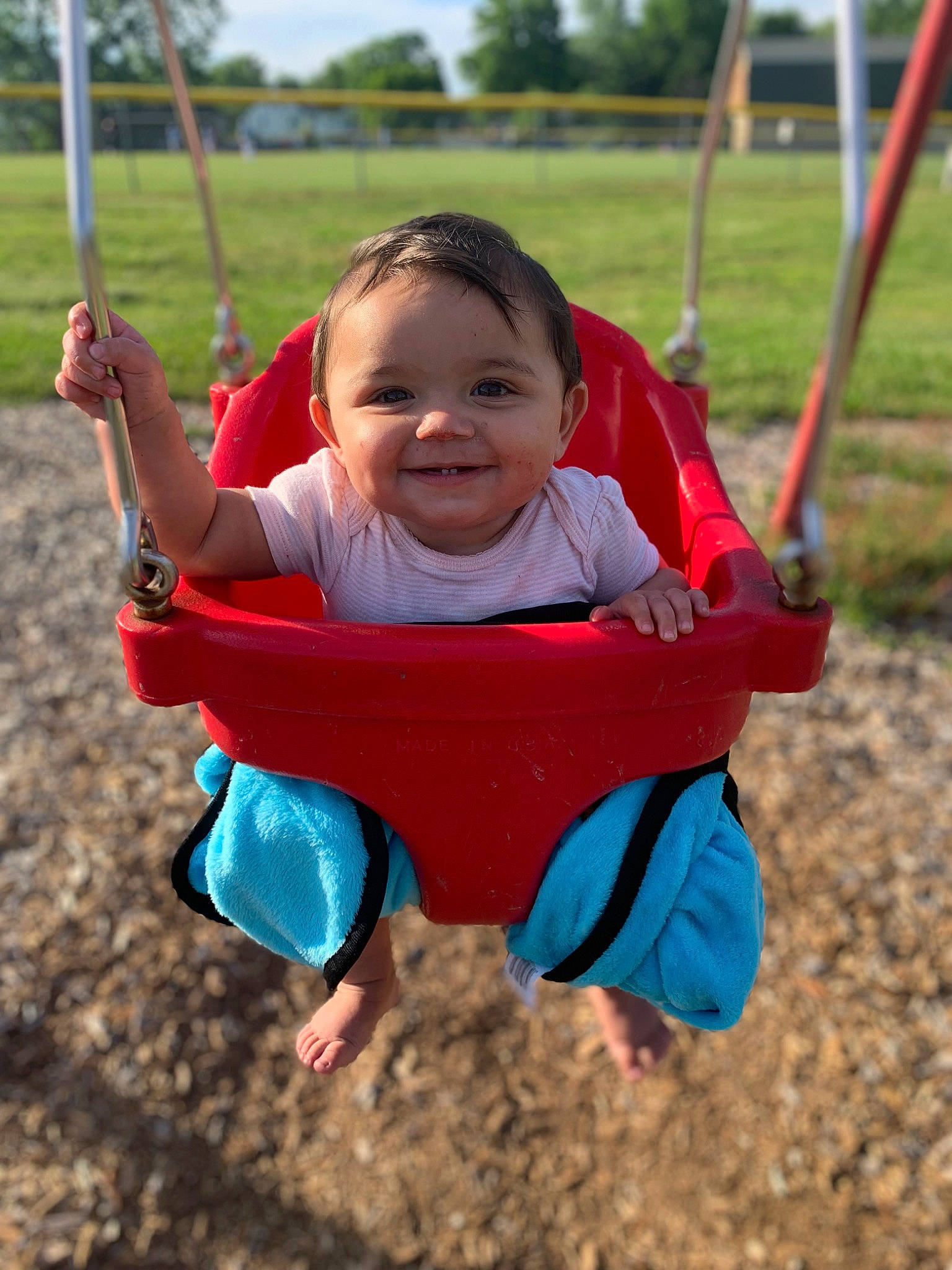 Jescira is registered to the contest to win money with this photo: baby, baby_toddler_clothing, city, facial_expression, fun, grass, happy, joy, leisure, outdoor_play_equipment, people_in_nature, person, plant, playground, recreation, skin, sky, smile, swing, toddler