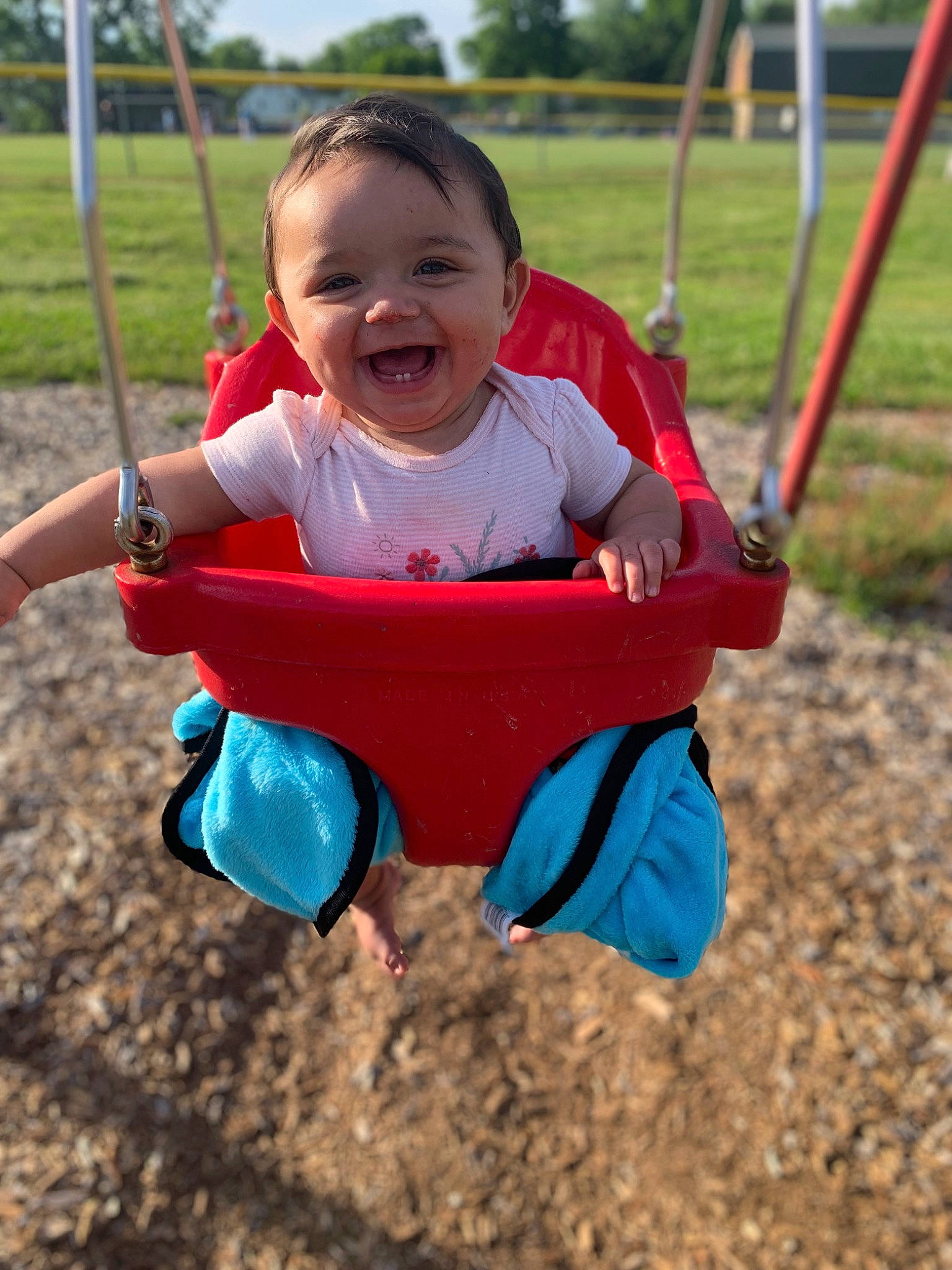 Jescira is registered to the contest to win money with this photo: baby, baby_toddler_clothing, city, eye, face, facial_expression, fun, grass, happy, joy, leisure, people_in_nature, person, playground, recreation, sky, smile, swing, toddler, tree