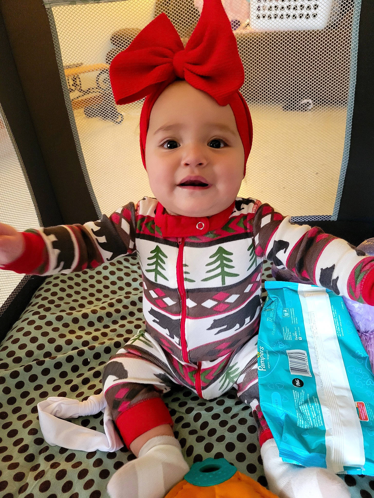 Clarissa is registered to the contest to win money with this photo: baby, baby_toddler_clothing, carmine, child, christmas_eve, costume_hat, event, flooring, fun, happy, head, holiday, pattern, person, sitting, sleeve, smile, sock, t_shirt, textile