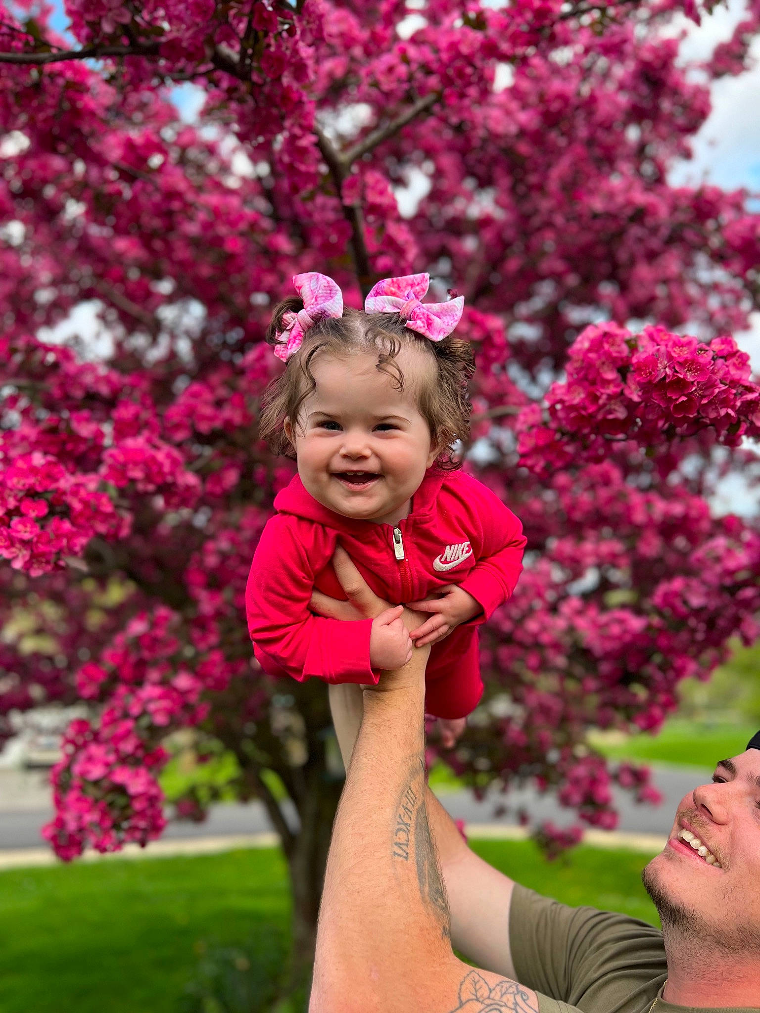 Hadley is registered to the contest to win money with this photo: botany, branch, face, flower, fun, gesture, grass, happy, headwear, joy, leaf, leisure, magenta, nature, people_in_nature, person, petal, pink, plant, red