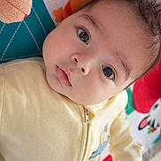 Rayan participe au concours pour gagner de l'argent avec cette photo : baby, blanket, child, closeup, colorful, cute, expression, eyes, face, head, indoor, infant, onesie, playmat, plush_toy, portrait, soft_toys, toy, yellow_clothing, young_child