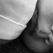 Oakley is registered to the contest to win money with this photo: child, face, closeup, black_and_white, sleeve, skin, texture, nose, mouth, soft, shadow, fabric, clothing, infant, head, portrait, young, detail, monochrome, blurred