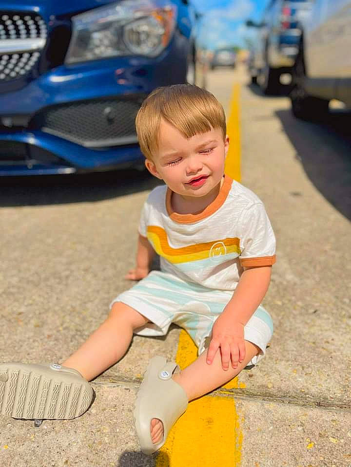 Liam joined the competition — help win amazing prizes! asphalt, automotive_design, automotive_exterior, automotive_lighting, automotive_tire, blue, car, child, grille, happy, hood, motor_vehicle, person, shoe, shorts, tire, toddler, vehicle, vehicle_door, white