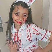 Calista a rejoint le concours — aidez-le/la à gagner de superbes lots ! child, girl, costume, nurse, blood_splatter, face_paint, long_hair, indoor, door, hand_on_hip, posing, makeup, headband, white_outfit, red, young_person, expression, portrait, person, wall