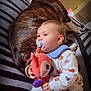 Kiara a rejoint le concours — aidez-le/la à gagner de superbes lots ! baby, brindle_dog, child, clothing, colorful, cozy, cuddling, cute, dog, floor, indoor, infant, pacifier, patterned_outfit, plush_toy, relaxed, resting, sleeping_dog, soft_toy, striped_blanket