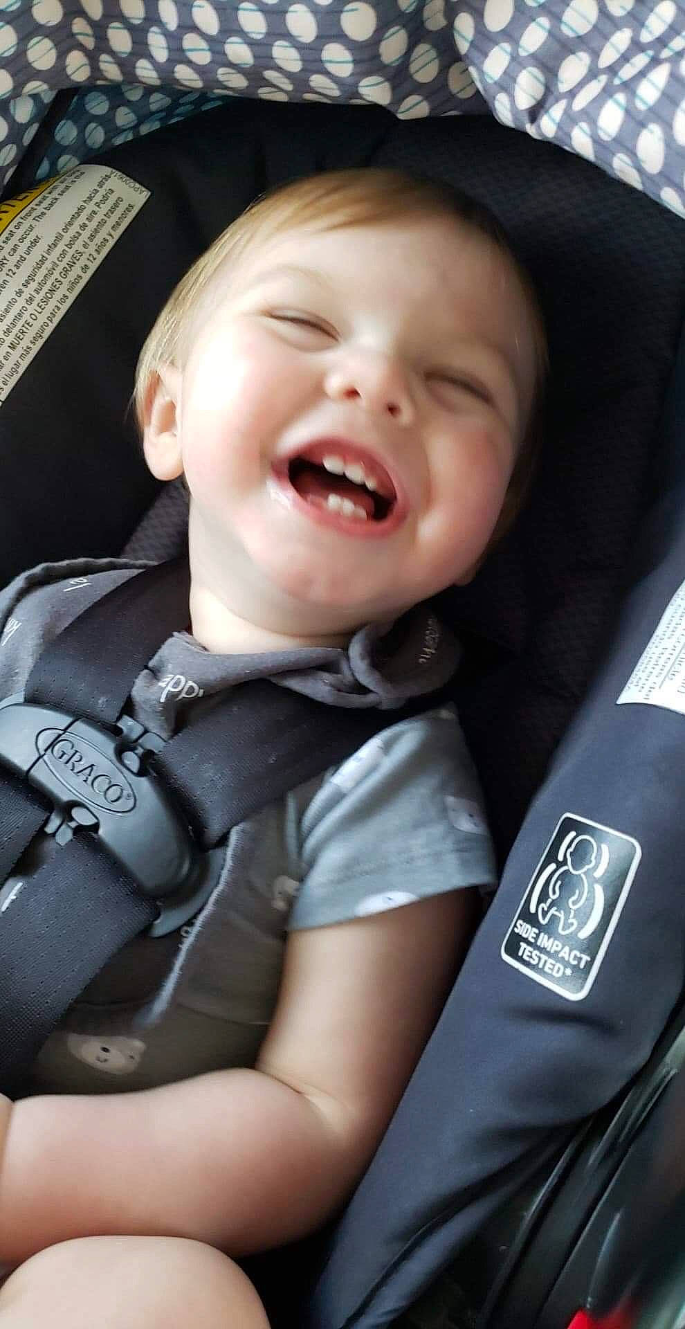 Augustus is registered to the contest to win money with this photo: auto_part, baby, baby_carriage, baby_in_car_seat, car_seat, cheek, child, facial_expression, laugh, nose, person, seat_belt, smile, toddler