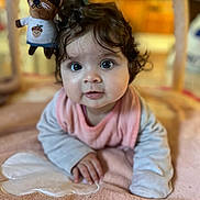 Esmée participe au concours pour gagner de l'argent avec cette photo : baby, infant, curly_hair, play_mat, plush_toy, pink, indoor, child, cute, wide_eyes, soft_texture, hand, clothing, face, portrait, toddler, toy, floor, expression, young_child