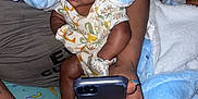 Zyaire is registered to the contest to win money with this photo: baby, bodypart, bonnet, cap, clothing, couch, cushion, electronics, face, finger, furniture, hand, hat, head, homedecor, mobilephone, person, phone, photography, portrait