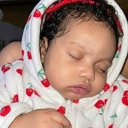 Kailly participe au concours pour gagner de l'argent avec cette photo : baby, sleeping, hoodie, cherry_pattern, red_bow, curly_hair, hand, closeup, child, infant, soft_fabric, zipper, cute, peaceful, indoor, portrait, skin, face, eyelids, cozy
