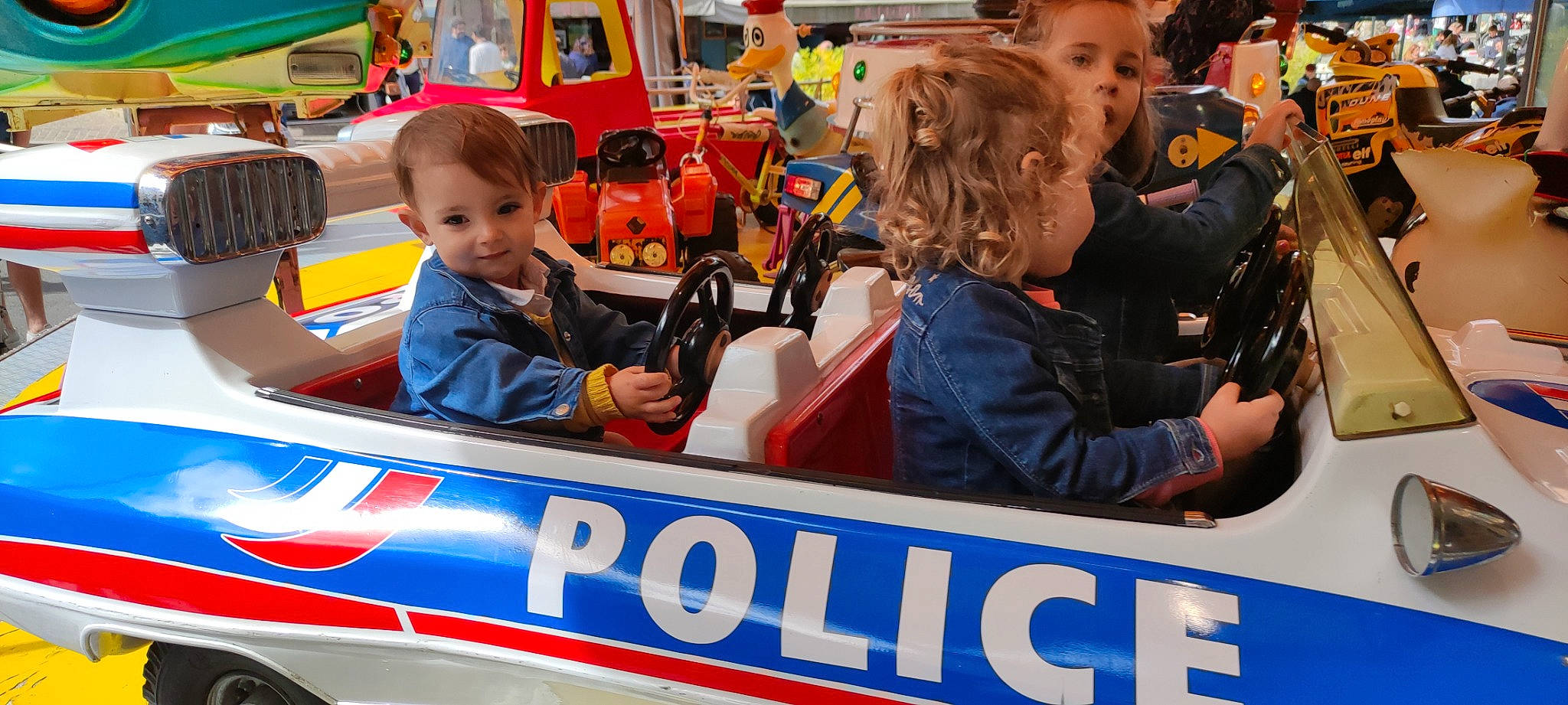 Melina a rejoint le concours — aidez-le/la à gagner de superbes lots ! auto_part, automotive_exterior, bumper, car, child, event, fan, festival, fun, jacket, joy, leisure, motor_vehicle, person, public_event, recreation, t_shirt, tire, toddler, toy