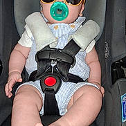 Samuel joined the competition — help win amazing prizes! baby, car_seat, sunglasses, pacifier, infant, child, safety_harness, cute, foot, clothing, seat, strap, casual, indoor, portrait, person, young_child, fashion, accessory, relaxing