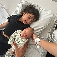 Elyo a rejoint le concours — aidez-le/la à gagner de superbes lots ! child, baby, bed, pillow, smiling, sleeping, person, hand, clothing, hospital_bracelet, newborn, family, indoor, caring, toddler, resting, infant, parent, holding, love