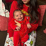 Jolene is registered to the contest to win money with this photo: baby, celebration, christmas_theme, couch, cozy, family, festive, happy, holding, holiday_pajamas, home, indoor, infant, long_hair, person, pillow, plaid_shoes, red_clothing, smile, woman