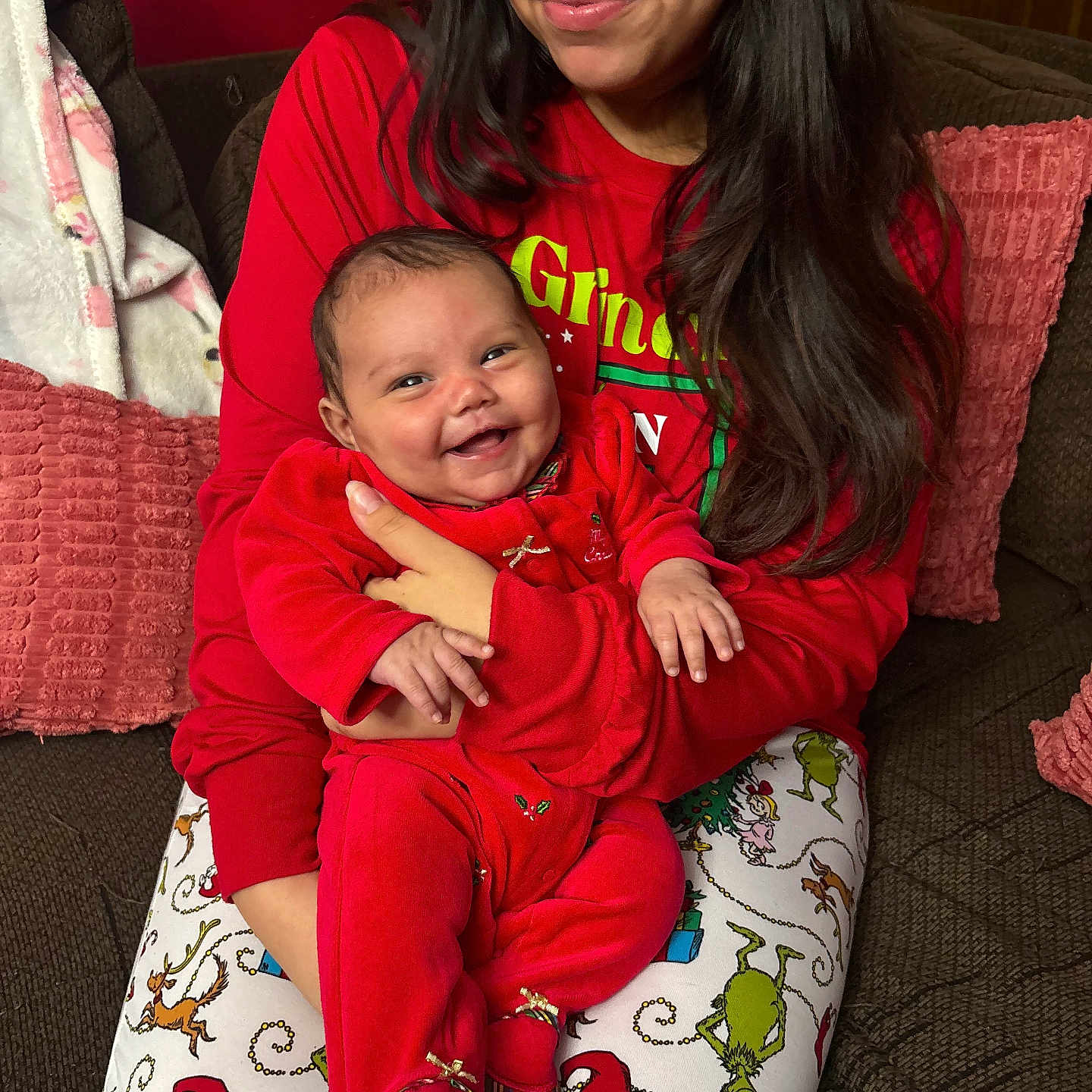 Jolene is registered to the contest to win money with this photo: baby, celebration, christmas_theme, couch, cozy, family, festive, happy, holding, holiday_pajamas, home, indoor, infant, long_hair, person, pillow, plaid_shoes, red_clothing, smile, woman