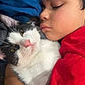 Rextire joined the competition — help win amazing prizes! child, cat, sleeping, hugging, black_and_white_cat, face, closeup, bed, blanket, comfort, cozy, rest, pet, animal, indoor, red_clothing, peaceful, cute, feline, human