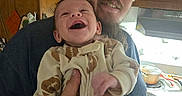 Wesley joined the competition — help win amazing prizes! baby, man, smile, laughing, cap, kitchen, cooking, stove, pot, wooden_cabinet, onesie, football_pattern, hand, facial_hair, person, indoors, happy, holding, family, parent