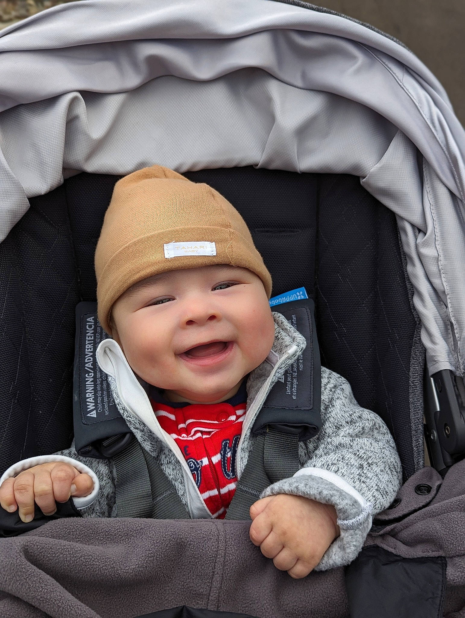 Tom is registered to the contest to win money with this photo: baby, beanie, cap, cheek, child, comfort, fashion_accessory, gesture, happy, headgear, headwear, hood, joy, outerwear, people, person, sitting, sleeve, smile, thumb