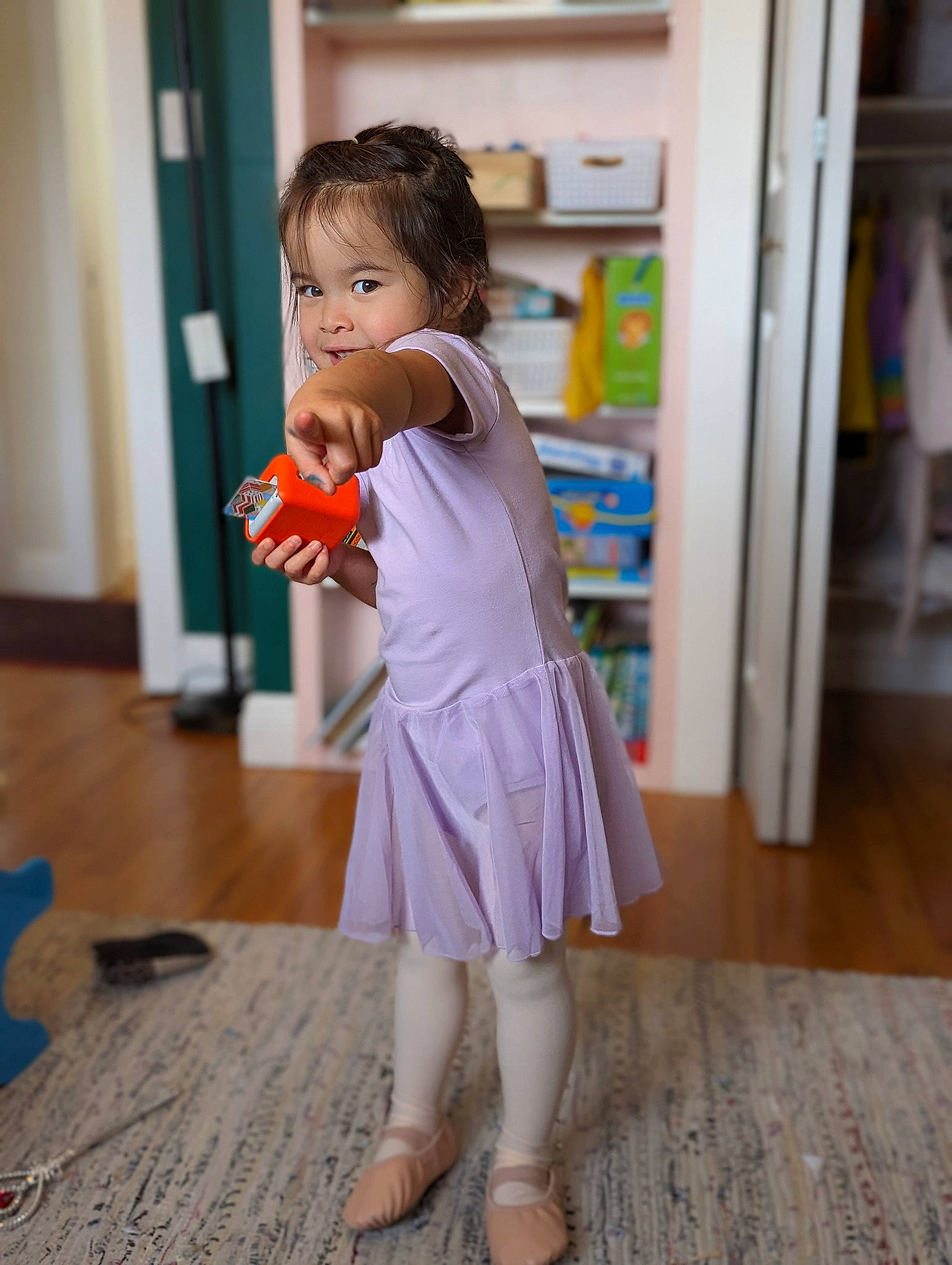 Lily joined the competition — help win amazing prizes! blond, dress, fashion_design, floor, flooring, fun, happy, hardwood, human_leg, joint, knee, one_piece_garment, peach, person, shelf, shoulder, sleeve, sock, toddler, wood