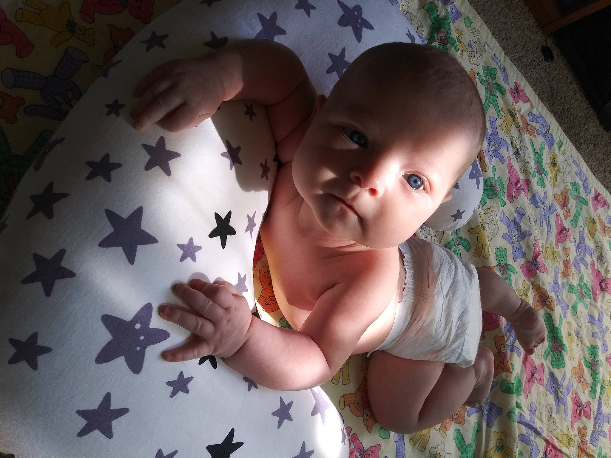 Edelweiss is registered to the contest to win money with this photo: arm, baby, baby_toddler_clothing, cheek, child, dress, facial_expression, finger, fun, gesture, hand, happy, mouth, nail, pattern, people_in_nature, person, sitting, skin, thumb