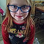 casual_clothing, chair, child, colorful, eyewear, face, floral_pattern, girl, glasses, home, indoor, kitchen, long_hair, person, portrait, red_hair, smiling, table, wooden_furniture, young