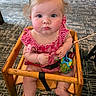 Izabella is registered to the contest to win money with this photo: baby, child, infant, high_chair, wooden_chair, portrait, sitting, pouting, rosy_cheeks, blonde_hair, blue_eyes, red_dress, striped_clothing, toy, teether, indoor, carpet, restaurant, furniture, photography