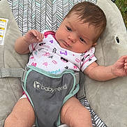 Autumn Rose is registered to the contest to win money with this photo: baby, infant, babyseat, babytrend, onesie, batgirl, outdoor, grass, wood, pattern, sitting, curious, child, cute, face, legs, arm, clothing, resting, babycare