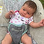 baby, infant, babyseat, babytrend, onesie, batgirl, outdoor, grass, wood, pattern, sitting, curious, child, cute, face, legs, arm, clothing, resting, babycare