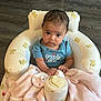 Selena joined the competition — help win amazing prizes! baby, infant, child, blue_shirt, blanket, pacifier, baby_bottle, baby_seat, teddy_bear_pattern, floor, couch, living_room, curly_hair, cute, sitting, indoor, soft_texture, pink_blanket, looking, small_hands