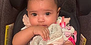 Selena joined the competition — help win amazing prizes! baby, infant, car_seat, blanket, soft_toy, child, cute, indoors, person, clothing, comfort, holding, face, skin, hair, eyes, seat, pink, warm, toddler