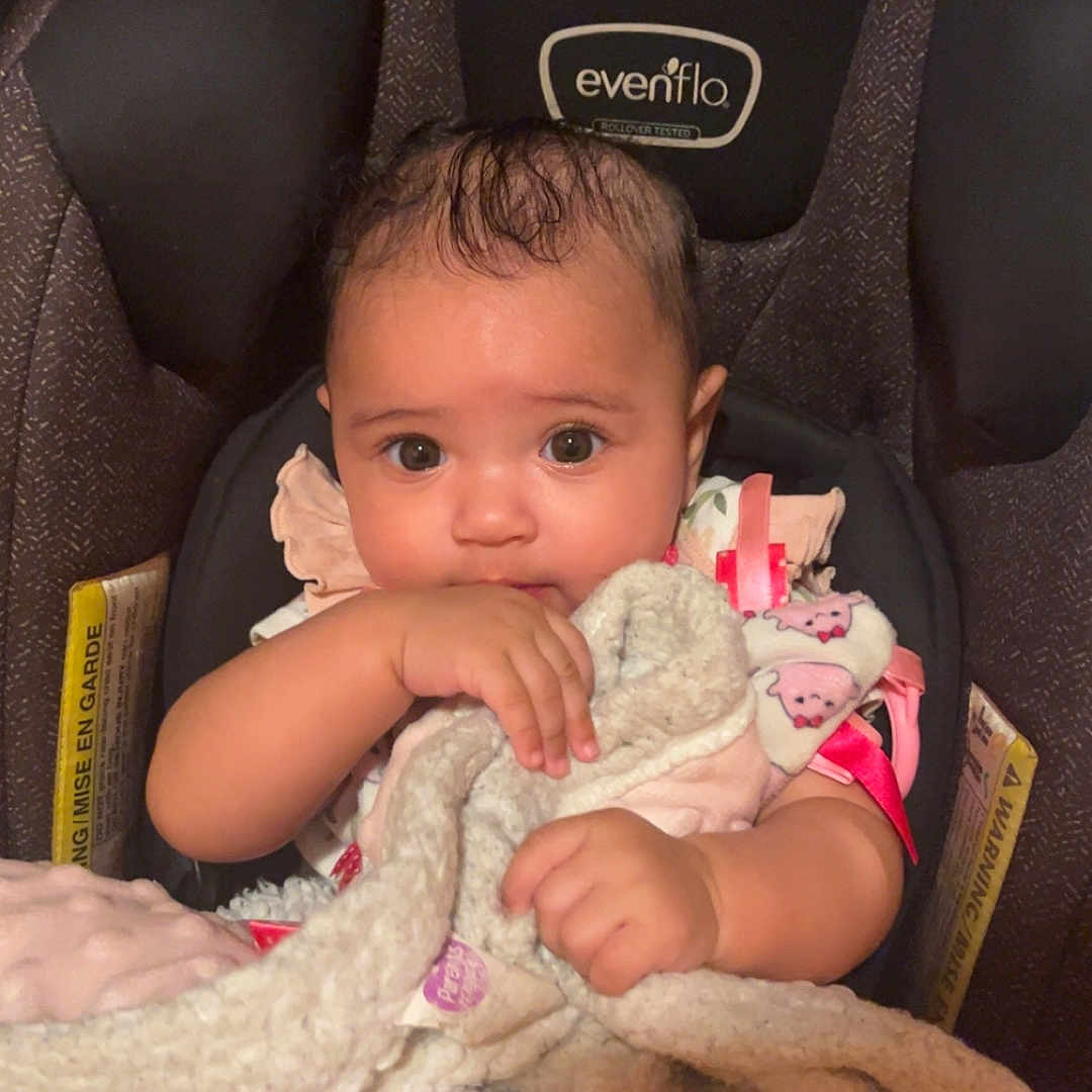Selena joined the competition — help win amazing prizes! baby, blanket, car_seat, child, clothing, comfort, cute, eyes, face, hair, holding, indoors, infant, person, pink, seat, skin, soft_toy, toddler, warm