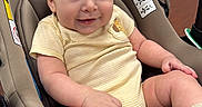 Bryan joined the competition — help win amazing prizes! baby, car_seat, chair, child, clothing, cute, furniture, happy, head, indoor, infant, person, portrait, seat, skin, smiling, socks, table, yellow_onesie, young